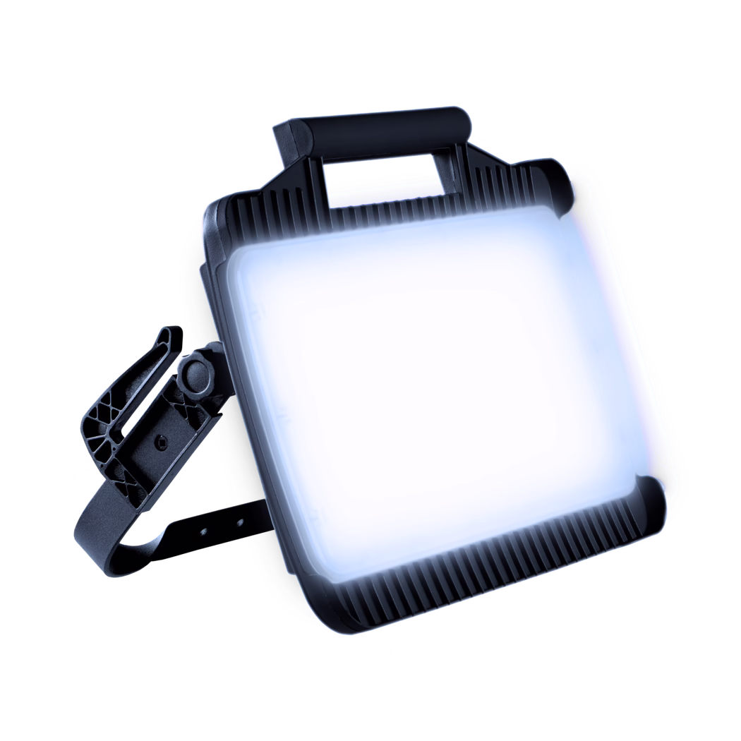 Close-up of a rectangular LED work light with a bright illuminated panel, black ribbed housing, a top handle and an adjustable mounting bracket, shown at an angle on a high-key white background.