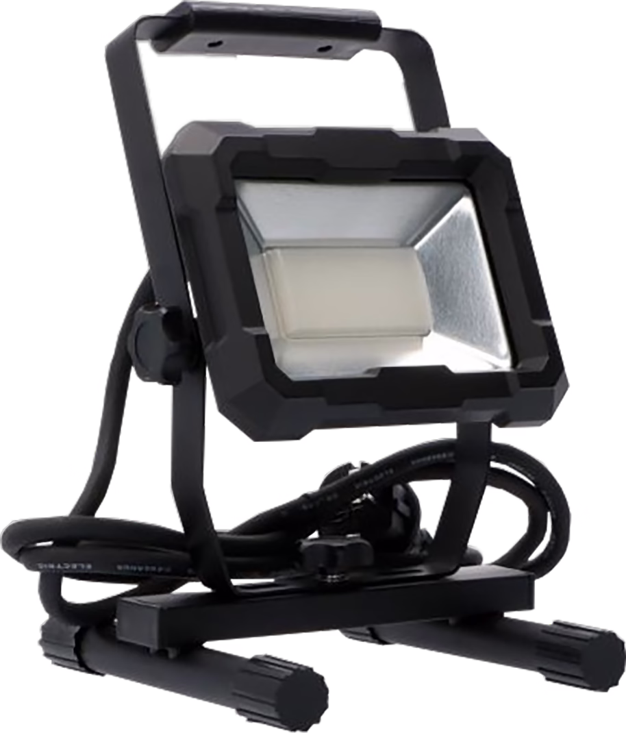 A compact black portable LED work light mounted on an adjustable metal frame and foldable stand. The rectangular lamp head features a rugged black plastic housing, a frosted central LED panel and a silver reflective inner surface. The light is fixed to a U-shaped bracket with wing screws that allow angle adjustment, and a coiled power cable is neatly placed around the base. The base consists of a flat rectangular platform supported by two tubular feet with textured end caps for stability. The overall design is functional and robust, suitable for job-site use, easy to transport and store.