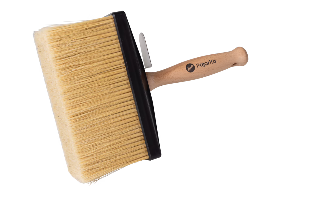 Large rectangular paint brush with a wide head and dense, natural-colored bristles held in a sturdy black plastic ferrule. The light wooden, ergonomically shaped handle bears the printed brand name "Pajarito" and a small metal hanging clip is attached near the ferrule. Photographed against a plain white background, the image highlights the texture of the bristles, the smooth wood finish of the handle and the brush’s suitability for covering large surfaces such as walls and ceilings for even paint application.
