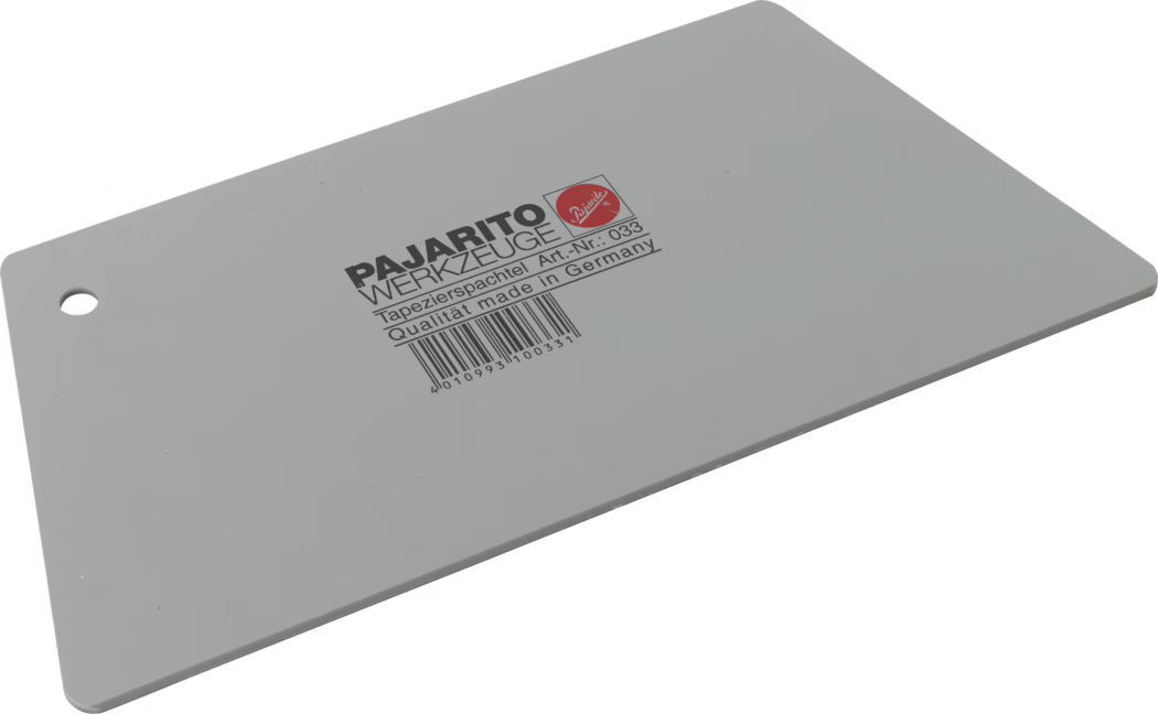 Pajarito_Dummy_Wallpaper scraper trapezoid_034821_2021-02 A gray wallpaper spatula labeled 'PAJARITO WERKZEUGE Tapetierspatchel Art.-Nr. 033 Qualität made in Germany' with a barcode.