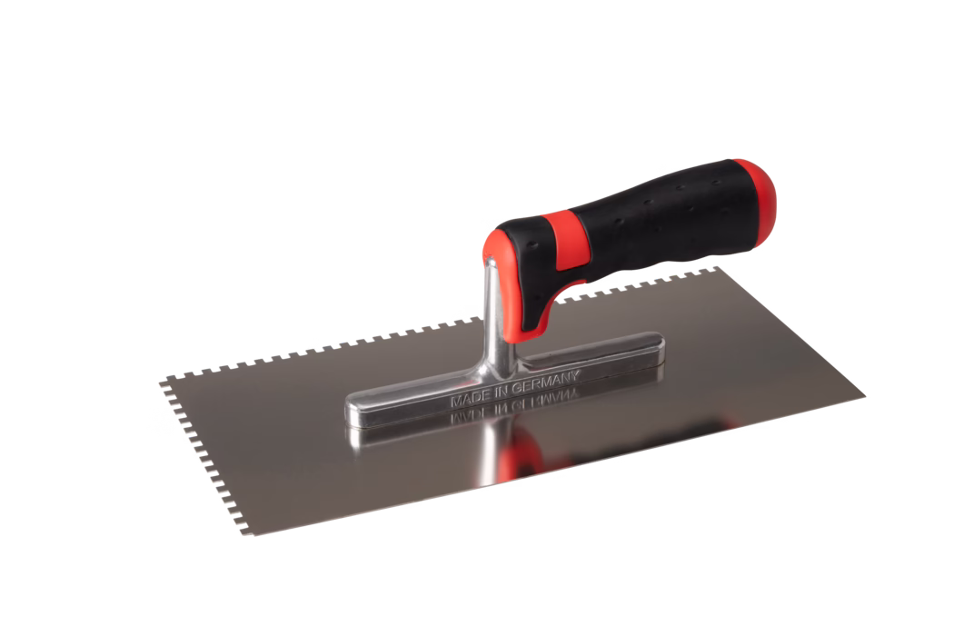 A stainless steel trowel with a serrated edge and a comfortable black rubber grip. The handle has red accents and the trowel is marked with 'MADE IN GERMANY'.