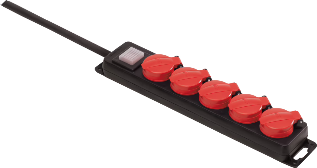 A black power strip with a long black cable on the left, featuring five red hinged protective covers over the sockets and a rectangular translucent white on/off switch near the cable. The strip is photographed at an angle on a white background; the red covers have a glossy finish and appear weatherproof, while the housing is sturdy black plastic with mounting holes at the ends.
