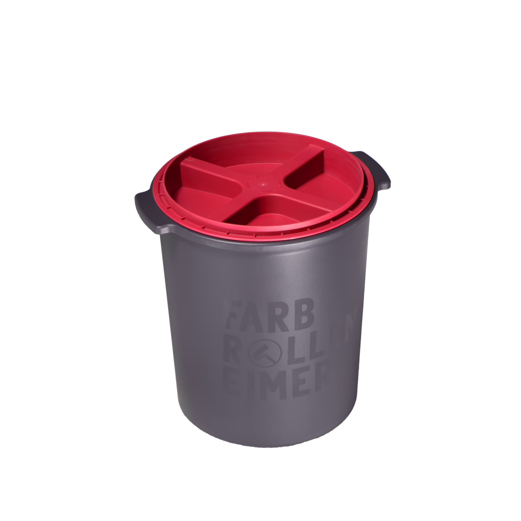 High-resolution product photo of a grey cylindrical plastic paint bucket photographed on a white background from a slightly elevated, three-quarter angle. The bucket features integrated side handles and a contrasting red plastic insert lid with a recessed, cross-shaped (X) compartment layout that sits flush inside the rim; the insert is designed to hold tools or to separate contents. The matte grey body displays subtle molded branding text reading 'FARB ROLLEN EIMER' and a small circular logo; lighting emphasizes the smooth plastic texture, molded edges and the functional details of the lid and handles. The composition is clean and studio-lit, suitable for e-commerce, catalog or instructional use.