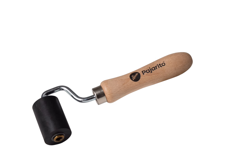 Pajarito_Dummy_Pressure roller hard rubber small_159651_2021-02 A paint roller with a black roller head and a wooden handle. The handle features a brand name 'Pajarito' printed on it. The roller is designed for applying paint smoothly onto surfaces.